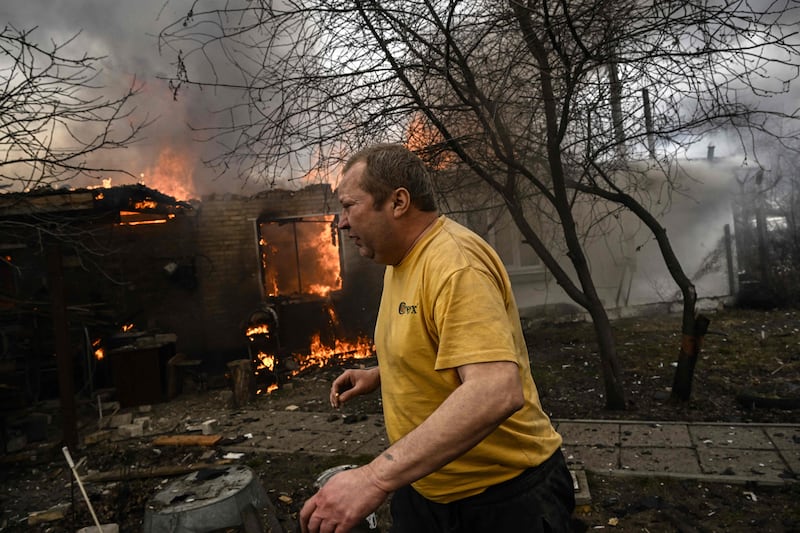 Yevghen Zbormyrsky, 49, runs in front of his burning house after being shelled in the city of Irpin, outside Kyiv. AFP