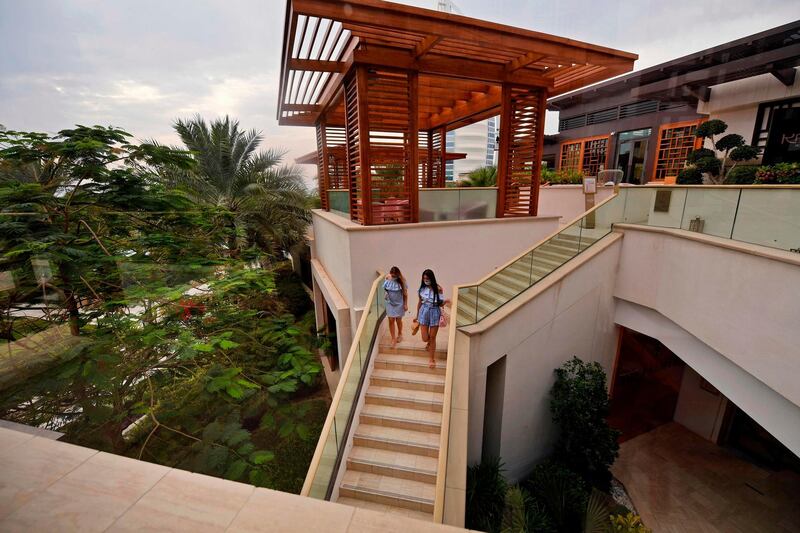 Guests wearing masks and gloves descend a staircase at the Jumeirah al-Naseem hotel in Dubai.  AFP