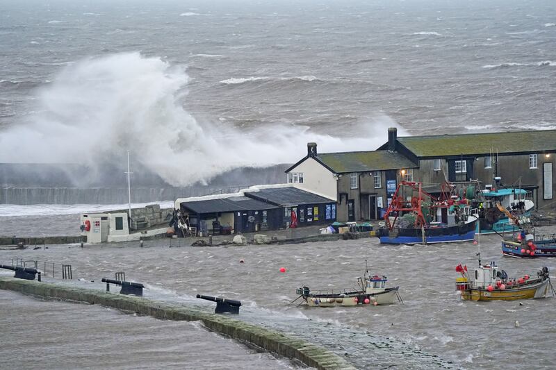 Waves crash over the sea wall at the harbour in Lyme Regis in Dorset, south-west England. PA