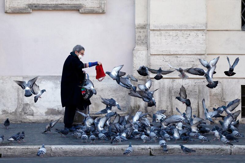 A woman feeds pigeons in Rome. AP