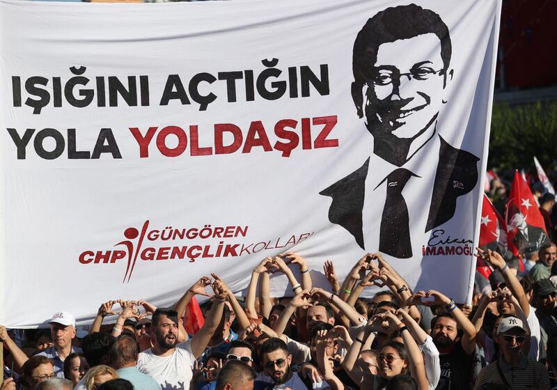 Supporters of Mr Imamoglu hold Turkish flags during the handover ceremony. EPA