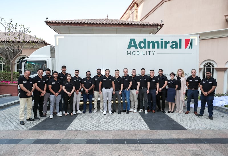 Admiral staff pose with one of the electric lorries. The company will supply the vehicles through a partnership with Chinese vehicle maker Geely Farizon