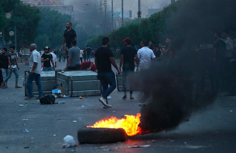 Protesters burn tyres and block a street during a demonstration in Baghdad. AP Photo