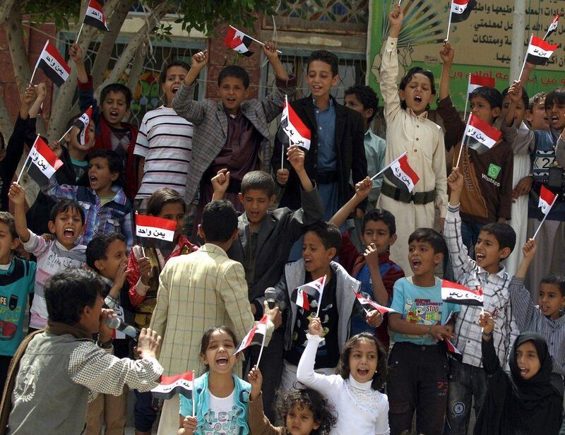 Yemeni children hold their national flag during a protest in the capital Sanaa against the Saudi-led military operations, on June 6, 2015. The Saudi-led coalition has been bombing the Iran-backed Huthi rebels and their allies since March 2015. AFP PHOTO / MOHAMMED HUWAIS
