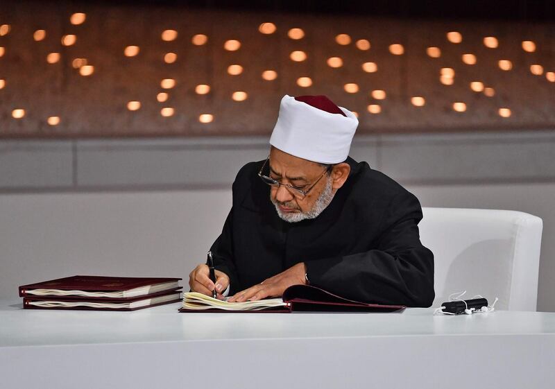 Dr Ahmad Al Tayeb signs the document. AFP