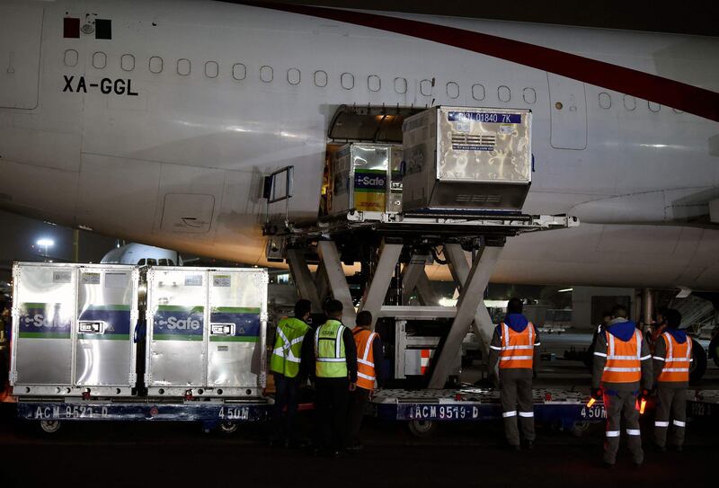 Employees unload shipping containers of the AstraZeneca Covid-19 vaccine from the US from an Aero Union airplane at Benito Juarez International Airport in Mexico City. AFP