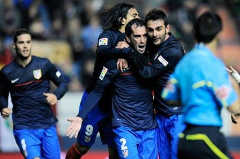 Diego Godin, centre, scored the only goal of the game between Atletico Madrid and Osasuna.