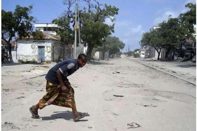A boy runs across Howlwadag Street in Mogadishu during the third day of fighting between Somali government forces and Islamist rebels in Mogadishu.
