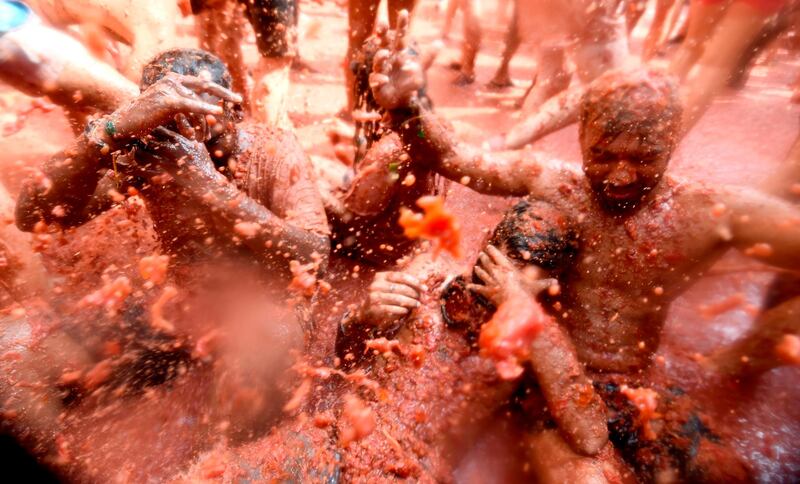 Participants slosh in tomato puree. AFP