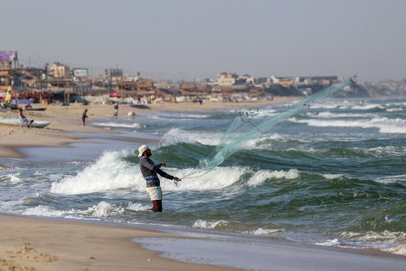 A fisherman casts his net from the shore. AFP