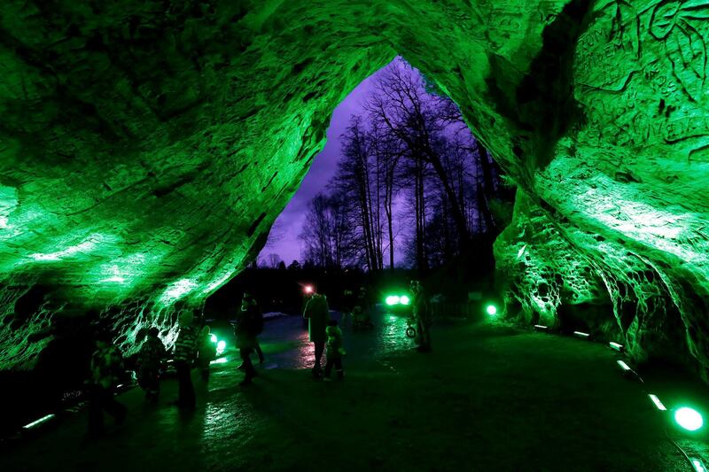 Visitors view Gutman's Cave, that has been illuminated in green for St Patrick's Day, in Sigulda, Latvia. Around 670 sites in 66 different countries take part in Tourism Ireland's annual initiative to add a green tint to famous buildings and sites. EPA