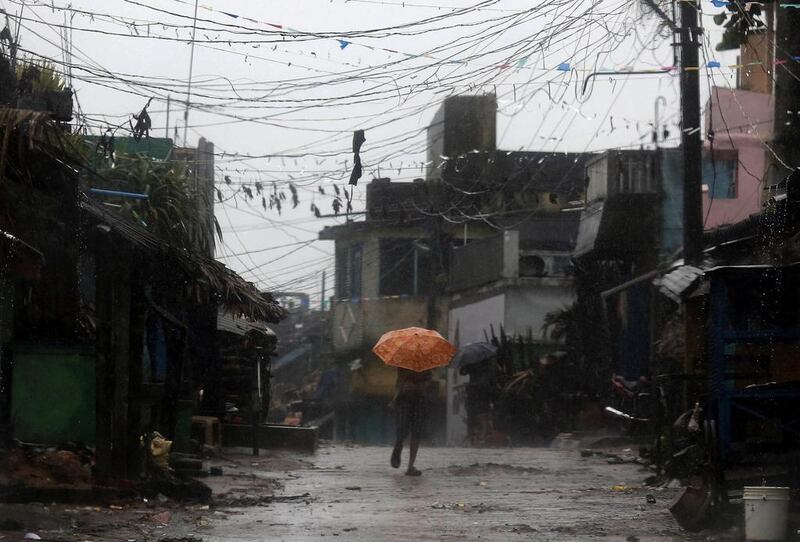 A man tries to cover himself with an umbrella during heavy rain brought by Cyclone Phailin as he moves towards a safer place at the village Donkuru in Srikakulam district in the southern Indian state of Andhra Pradesh. Reuters/Adnan Abidi