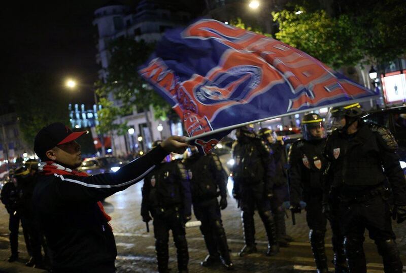 A PSG supporter celebrates at the Champs Elysees in Paris on Wednesday after the club won the Ligue 1 title. Kenzo Tribouillard / AFP / May 7, 2014