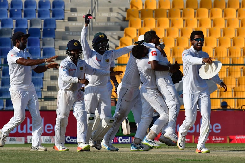 Rangana Herath (C) of Sri Lanka celebrates with his team after victory on the fifth day of the first Test cricket match between Sri Lanka and Pakistan at Sheikh Zayed Stadium in Abu Dhabi on October 2, 2017. / AFP PHOTO / GIUSEPPE CACACE