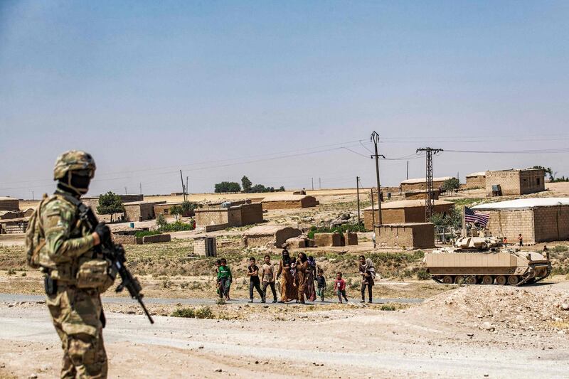 A US soldier surveys the area as locals approach, during a patrol in Rmelan, in Syria's north-eastern Hasakeh province. AFP