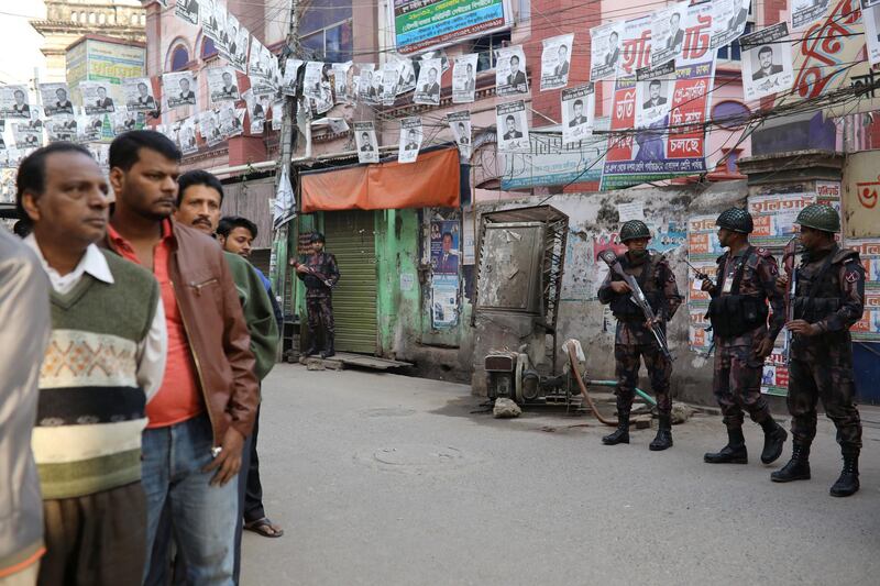 Law enforcement officials stand guard outside a voting center in Dhaka. Reuters