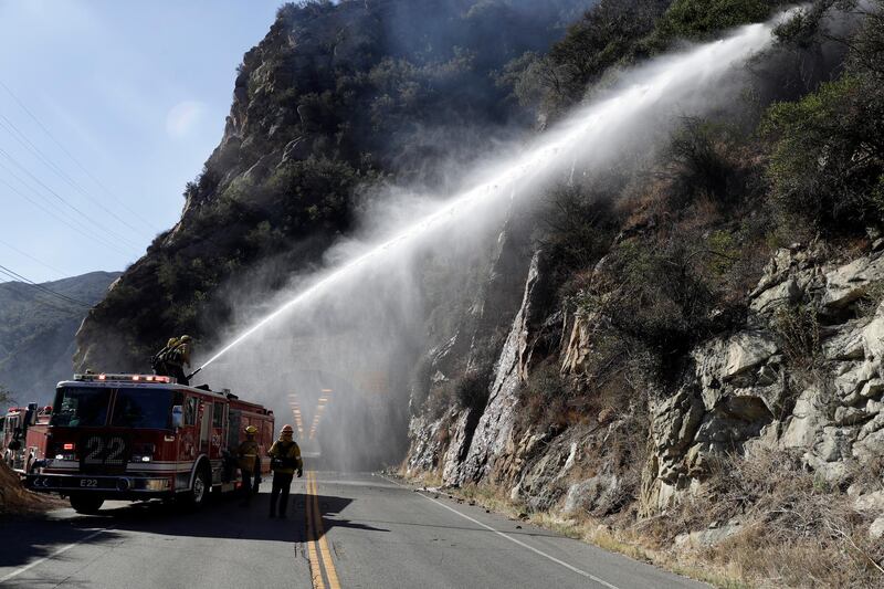 Firefighters hose down hot spots from a wildfire in Calabasas. AP Photo