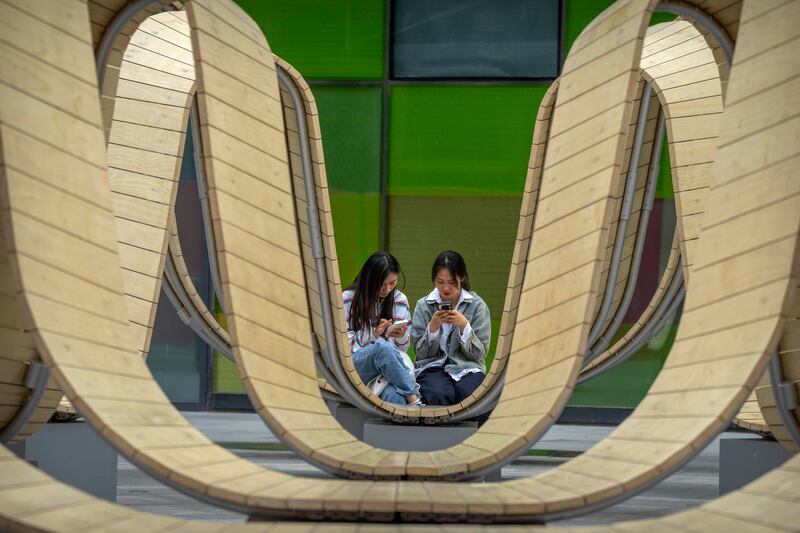 Shoppers consult their smartphones at a mall in Beijing, China, on Saturday. AP
