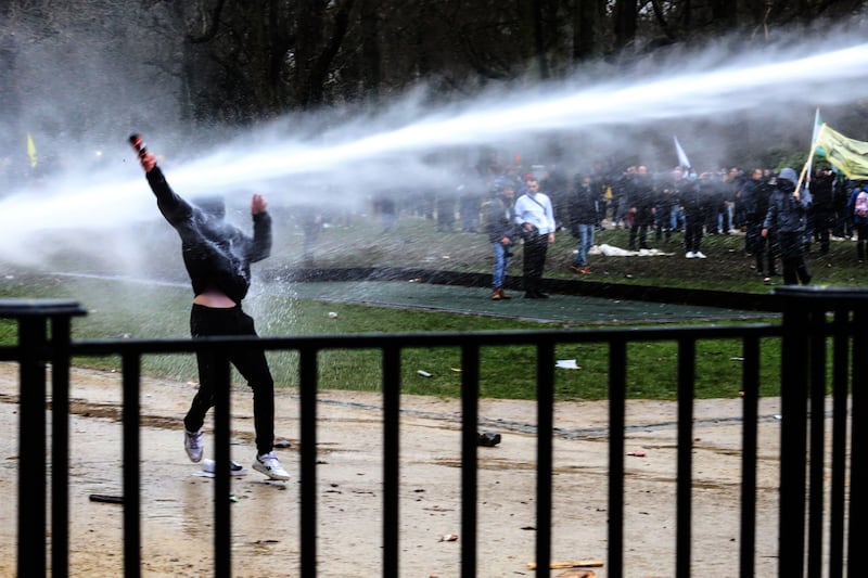 A demonstrator is sprayed by a water cannon as police confront an estimated 50,000 protesters. Bloomberg