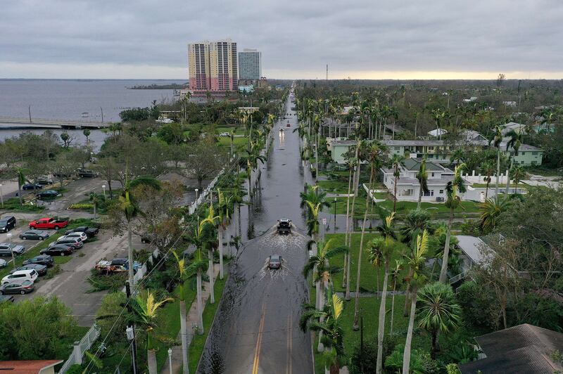 Vehicles make their way through a flooded area after Hurricane Ian tore across Fort Myers, bringing high winds, a storm surge and rain, causing severe damage. AFP