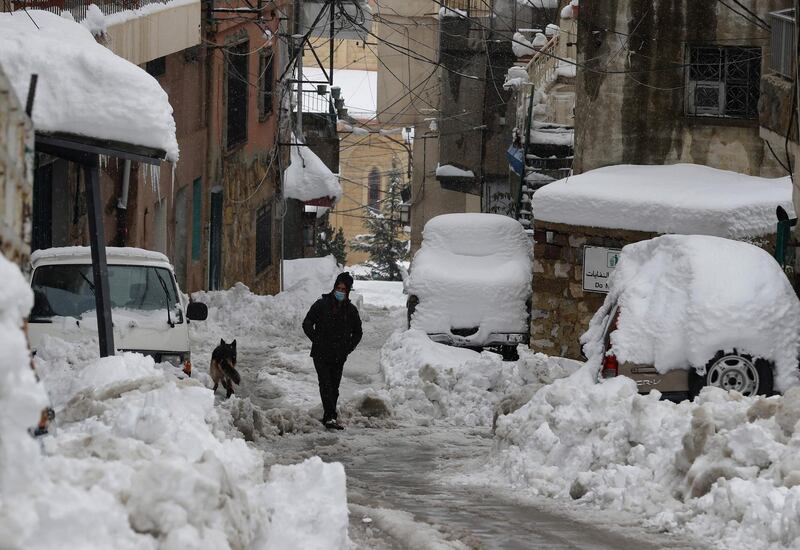 A man walks along a snow-covered street in the town of Bcharre in Mount Lebanon. AFP