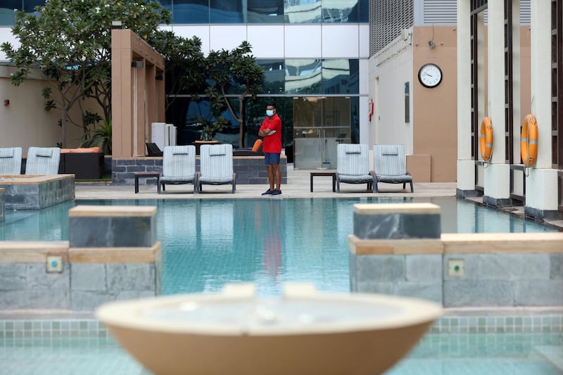 Dubai, United Arab Emirates - Reporter: N/A. Standalone. Covid-19/Coronavirus. Lifeguard Mamun watches over the pool with a face mask at the H Hotel in Dubai. Thursday, August 27th, 2020. Dubai. Chris Whiteoak / The National