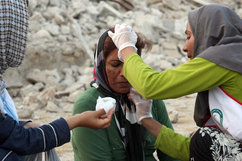 An Iranian woman receives medical treatment from aid workers in the town of Shonbeh, southeast of Bushehr, on April 9, 2013 after a powerful earthquake struck near the Gulf port city of Bushehr. The 6.1 magnitude quake killed at least 30 people and injured 800 but Iran's only nuclear power plant was left intact, officials said.    AFP PHOTO/FARS NEWS/MOHAMMAD FATEMI
 *** Local Caption ***  875351-01-08.jpg
