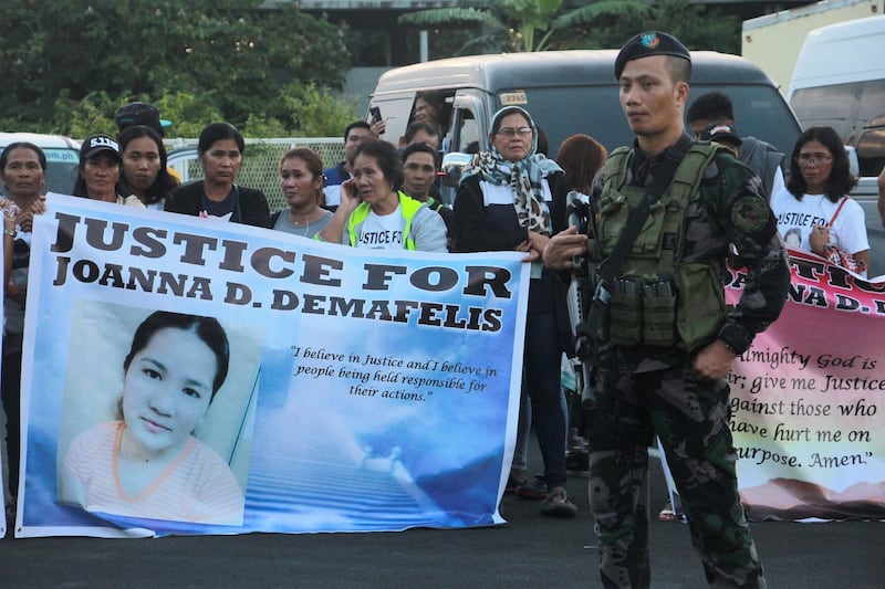 Relatives of Filipina worker Joanna Demafelis, whose body was found inside a freezer in Kuwait, hold banners as they wait for the arrival of Joanna's body from Manila at Iloilo International Airport in Iloilo province, central Philippines, on February 17, 2018.
The body of Filipina worker Joanna Demafelis arrived back in Manila from Kuwait to a tearful welcome on February 16, just days after Philippines President Rodrigo Duterte barred his nationals from working in the Gulf state. / AFP PHOTO / -