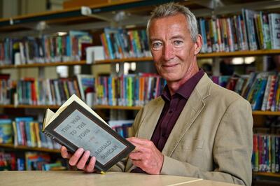 Charlie Studdy with the book that his mother borrowed in 1946. Photo: Bradford Council