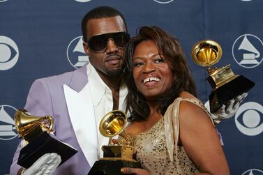 FILE - In this Feb.  8, 2006, file photo, Kanye West and his mother, Donda, hold his three awards backstage at the 48th Annual Grammy Awards in Los Angeles.  West won for best rap album, solo and song.  Kanye West unveiled his 10th studio album, “Donda,” in front of a packed crowd in Atlanta.  His album was named after his mother, who died at the age of 58 following plastic surgery complications in 2007.  (AP Photo / Reed Saxon, File)