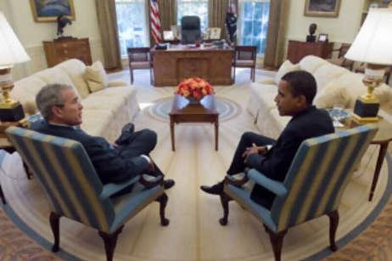 George Bush and Barack Obama meet in the Oval Office of the White House.