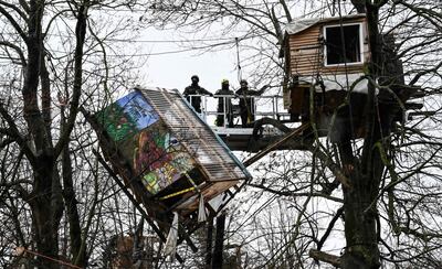 Police tear down a treehouse put up by environmentalists. AFP 