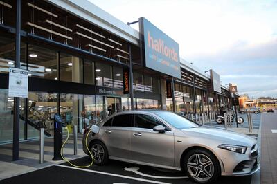 An electric car is seen at a charging point at Halfords in Rugby, Britain, November 19, 2020. REUTERS/Molly Darlington