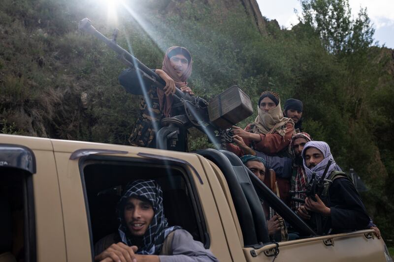 Taliban fighters ride in a vehicle on a road in Wardak province, Afghanistan. AP