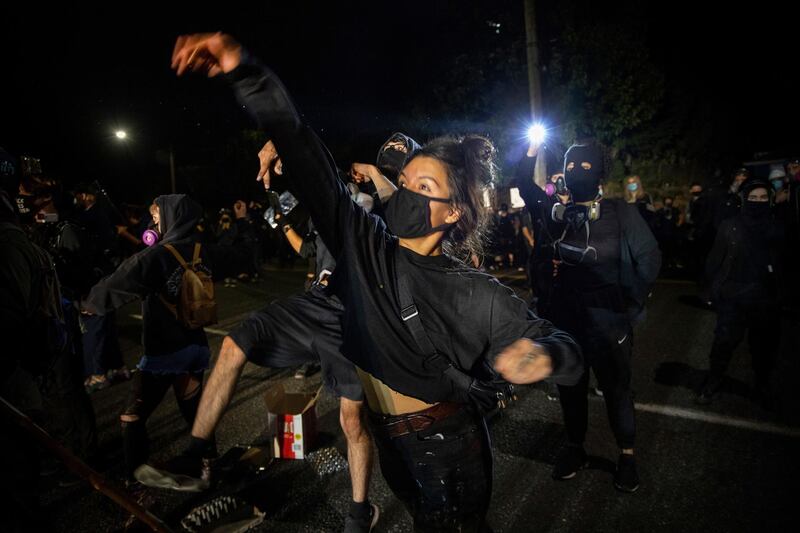 Protesters throw eggs at police during the nightly protests at a Portland police precinct  in Portland, Ore. Oregon State Police will return to Portland to help local authorities after the fatal shooting of a man.  AFP