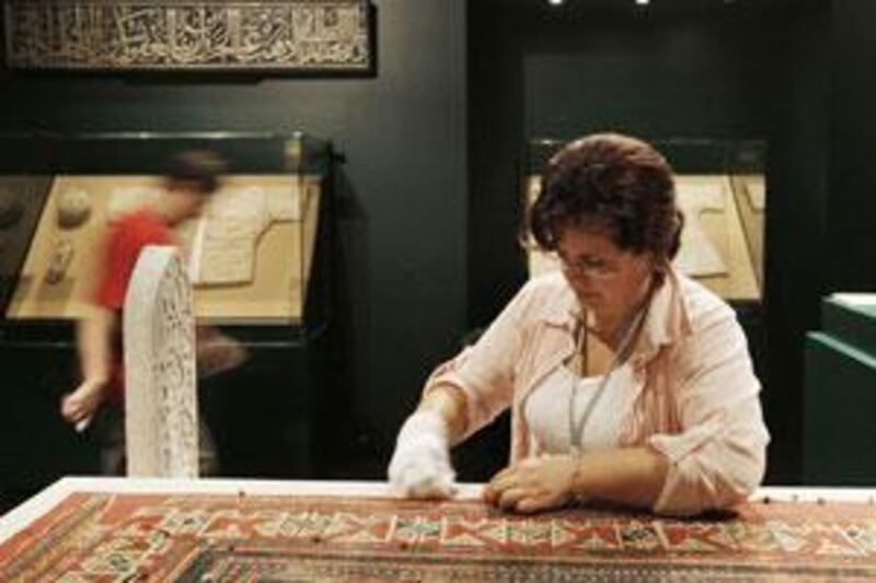 Gunul Tekeli, curator of the carpet section of the Turkish Islamic Art Museum in Istanbul, prepares a 15th-century prayer rug from the Seyh Baba Yusuf Mosque for exhibition.