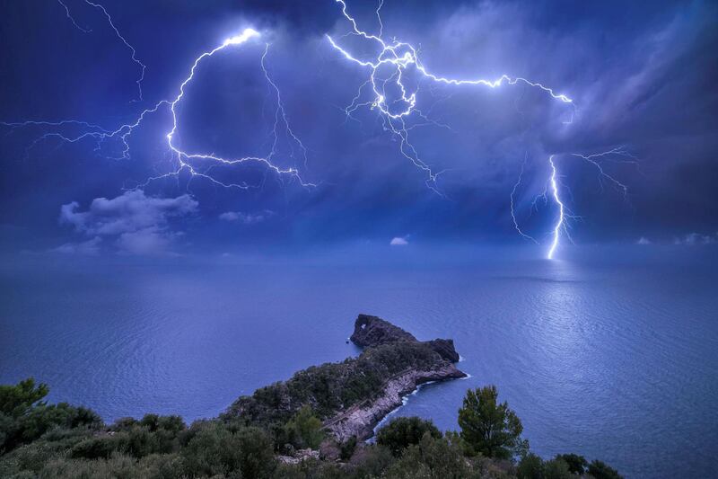 'Sa Foradada Storm', Marc Marco Ripoll: 'I tried many times to catch a good lightning strike behind this rock called Sa Foradada, [Spain,] but every time I tried, the conditions were not so good. I didn't have the moon in the sky to illuminate the scene, or the lightning was too far away. This night I knew that a big storm was approaching Mallorca and all the conditions were perfect. I don't remember if the moon was full, but I remember that it was very big. This was perfect, because the moon was going to illuminate all the land and the sea and give more colour to the scene. I chose my composition, and I shot many pictures until the storm fell on me. This is one of the pictures I took that night in Sa Foradada. To see the storm and the lightning that night was something amazing.'