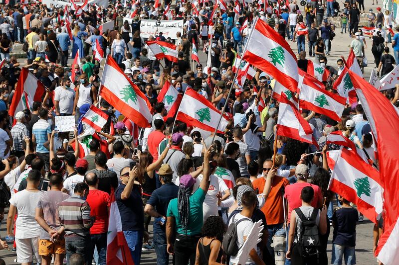 Protesters wave Lebanese national flags as they shout slogans against the government. AP