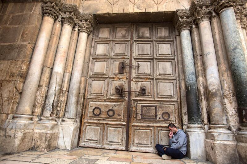 A Palestinian Christian named Nidal Aboud, 24, from the Old City of Jerusalem sits on the ground against the gigantic wooden doors of the  Church of the Holy Sepulchre in the Old City of Jerusalem on Monday February 26,2018.The Church of the Holy Sepulchre  remained closed for a second day after church leaders in Jerusalem closed it to protest against Israeli's announced plans by the cityÕs municipality earlier this month to collect property tax (arnona) from church-owned properties on which there are no houses of worship.
Nadal said he was in mourning for the state of Christians in the Holy Land and said he never in his life saw the church closed before .
(Photo by Heidi Levine for The National).