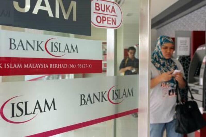 A Muslim customer exits a branch of BIMB Holdings Bhd., formerly known as Bank Islam Malaysia Bhd., in Kuala Lumpur, Malaysia, on Saturday, Sept. 25, 2010. BIMB Holdings provides all aspects of Islamic banking services. Photographer: Goh Seng Chong/Bloomberg
