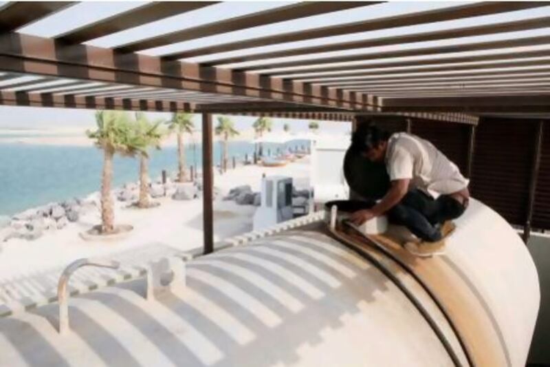 A maintenance technician at Royal Island Beach Club checks the diesel tank that holds fuel for the resort's generators.