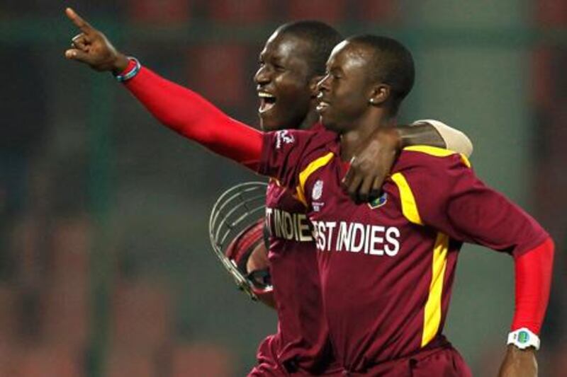 West Indies' Kemar Roach (R) celebrates taking a hat-trick after dismissing Netherlands' Berend Westdijk with his captain Darren Sammy during their ICC Cricket World Cup group B match in New Delhi February 28, 2011.  REUTERS/Adnan Abidi (INDIA - Tags: SPORT CRICKET)  