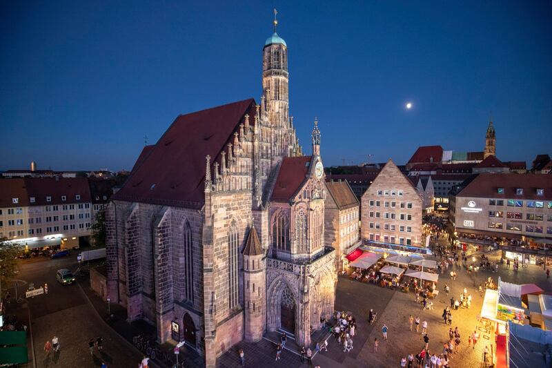 View from a big wheel to the Frauenkirche at the main market in the old town, Friday, July 31, 2020, in Nuremberg, Germany. The Nuremberg city administration and the South German Showmen's Association have developed an alternative because of the public festivals cancelled by the coronavirus - the "Nuremberg Summer Days." The decentralized folk festival takes place throughout the city with small attractions. (Daniel Karmann/dpa via AP)