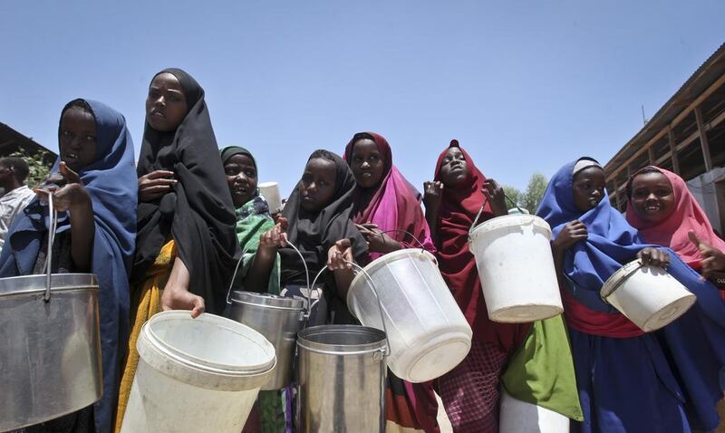 Displaced Somali girls who fled the drought in southern Somalia stand in a queue to receive food handouts at a feeding center in a camp in Mogadishu last month. (AP Photo/Farah Abdi Warsameh)
