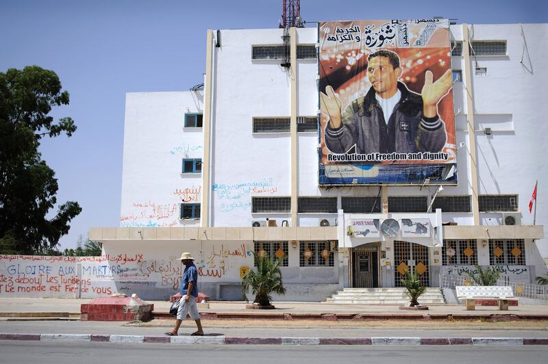 A man walks past revolutionary graffiti and a poster celebrating the martyr Mohammed Bouazizi in Sidi Bouzid, Tunisia. Photo: Lindsay Mackenzie for The National.