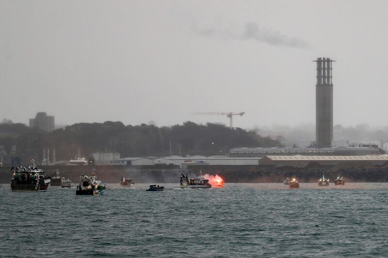 A flare is lit as French fishing boats protest in front of the port of Saint Helier. AFP