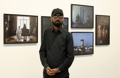 Morteza Niknahad with his 'Big Fish' photographs, which are on display as part of the Vantage Point Sharjah exhibition. Pawan Singh / The National