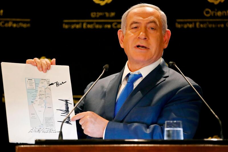 Israeli Prime Minister Banjamin Netanyahu displays a map of Israel indicating the Golan Heights are inside the state's borders, signed by US president Donald Trump and handed over to him by the president's son-in-law and adviser Jared Kushner during the same day, as he speaks in a hotel of Jerusalem on May 30, 2019. Israeli Prime Minister Benjamin Netanyahu was confronted with one of the biggest defeats of his political career on May 30 after failing to form a coalition and opting instead to hold an unprecedented second election. / AFP / Thomas COEX
