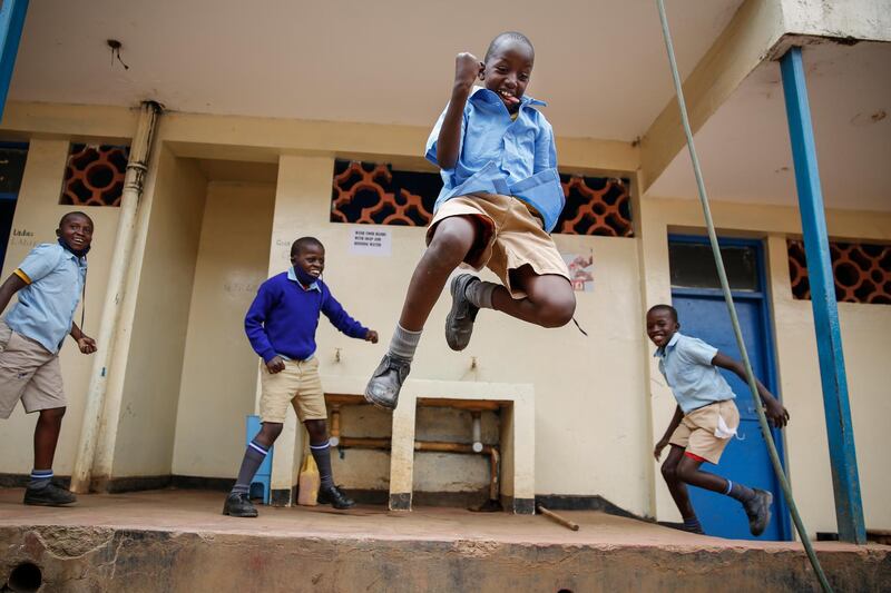 Schoolchildren joke around and play at the Olympic Primary School in Kibera, one of the capital Nairobi's poorest areas, in Kenya Monday, Oct. 12, 2020. Kenya partially re-opened schools on Monday to allow those students due for examinations which had been postponed to prepare, following a total closure of all educational institutions enacted since March to curb the spread of the coronavirus pandemic. (AP Photo/Brian Inganga)