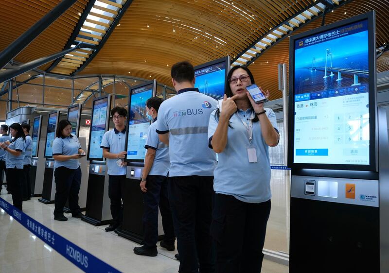 A staff worker demonstrates how to use the ticket machine. AP Photo